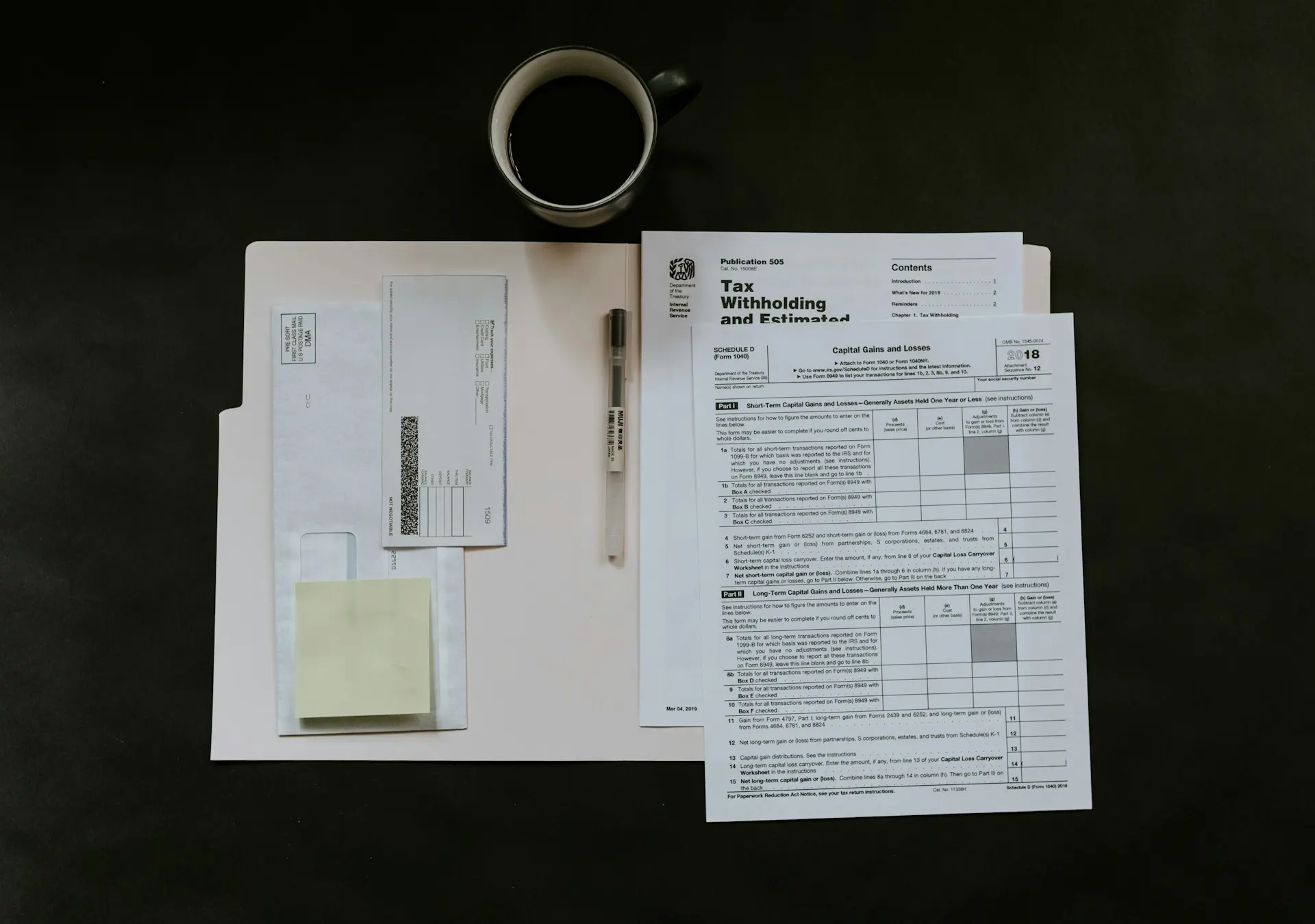 Una carpeta abierta con papeles de impuestos, una pluma y un café