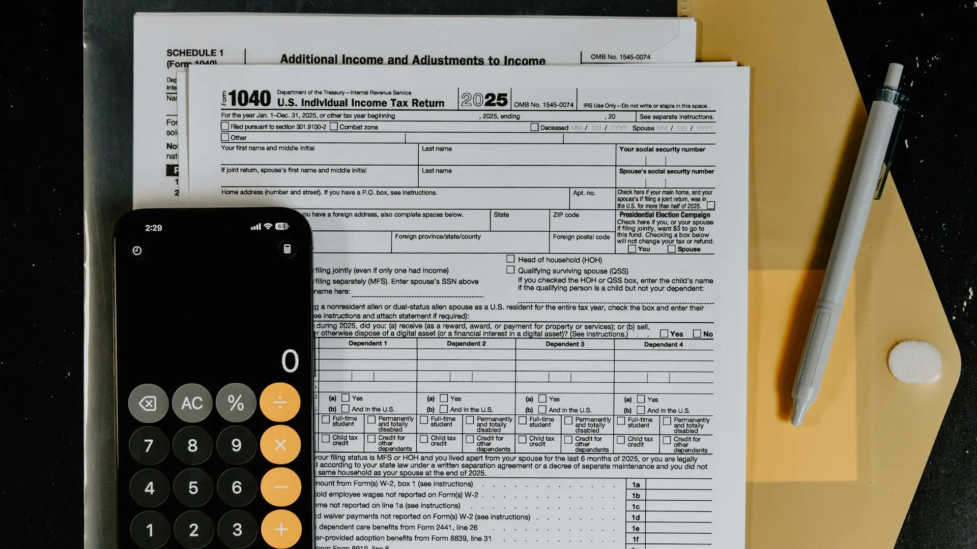Formulario de impuestos 1040 con una calculadora y una pluma