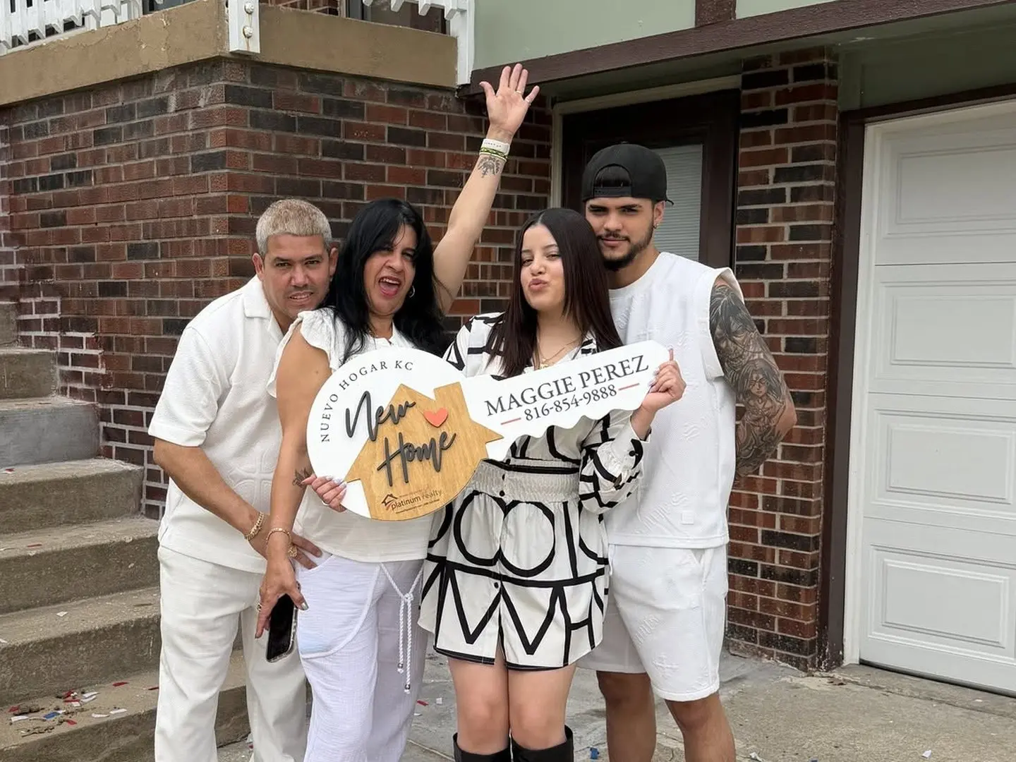 Una familia con la llave de Nuevo Hogar KC frente a la entrada de su casa nueva