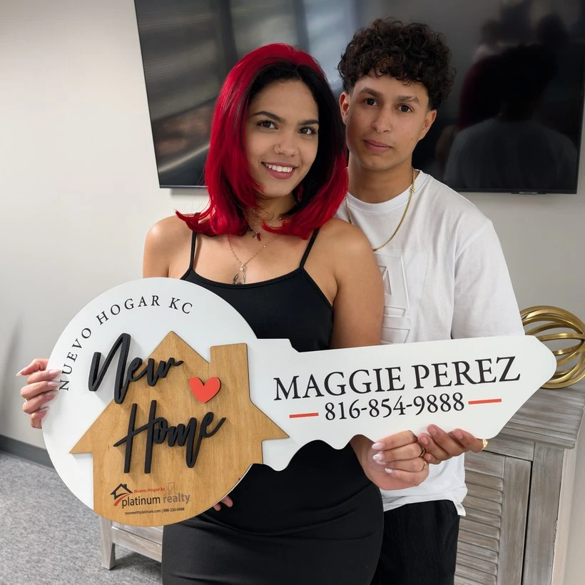Pareja cliente con el letrero de llave de Nuevo Hogar KC
